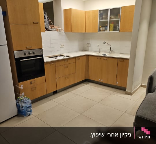 מטבח נקי ומסודר עם ארונות עץ ורצפה מבריקה
